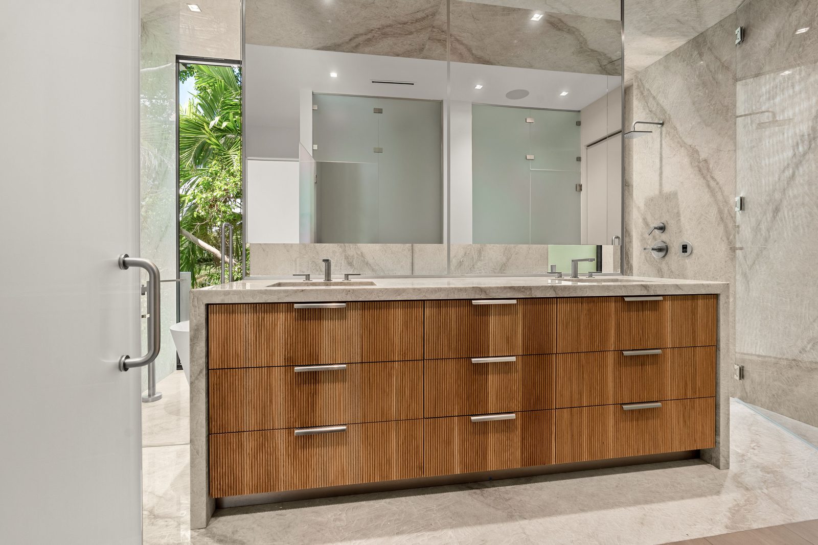 Walnut double vanity with stone surround in a Bay Harbor Islands home