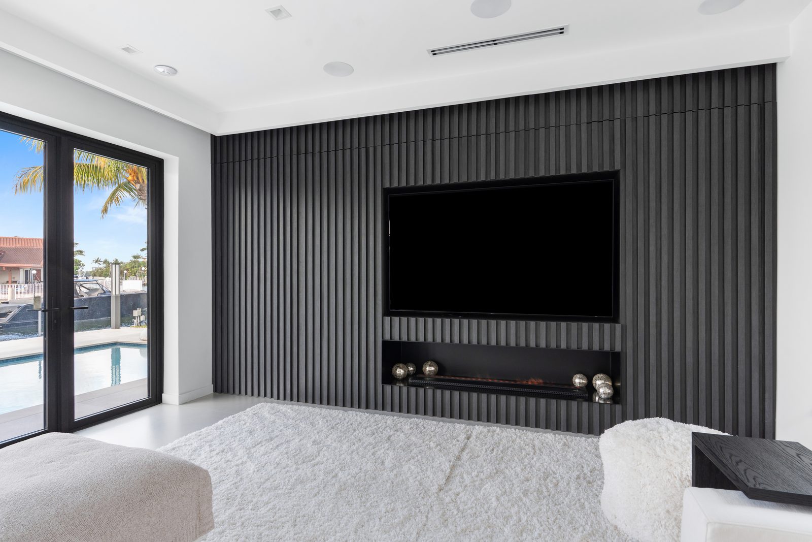 Fluted dark media wall in a canal-front North Miami Beach house