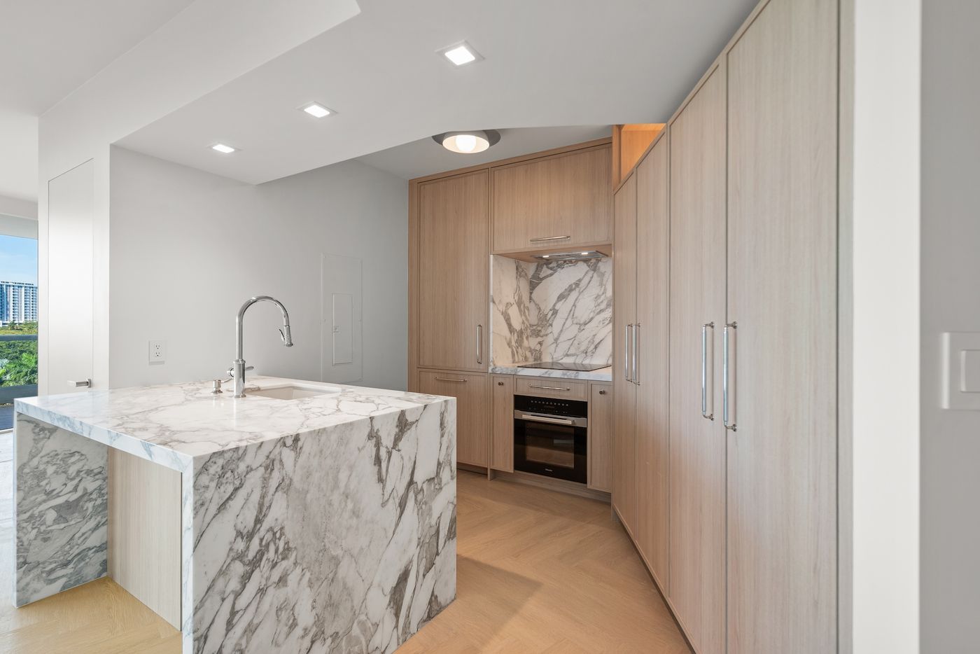 White oak custom kitchen with marble waterfall island, Brickell Avenue, Miami